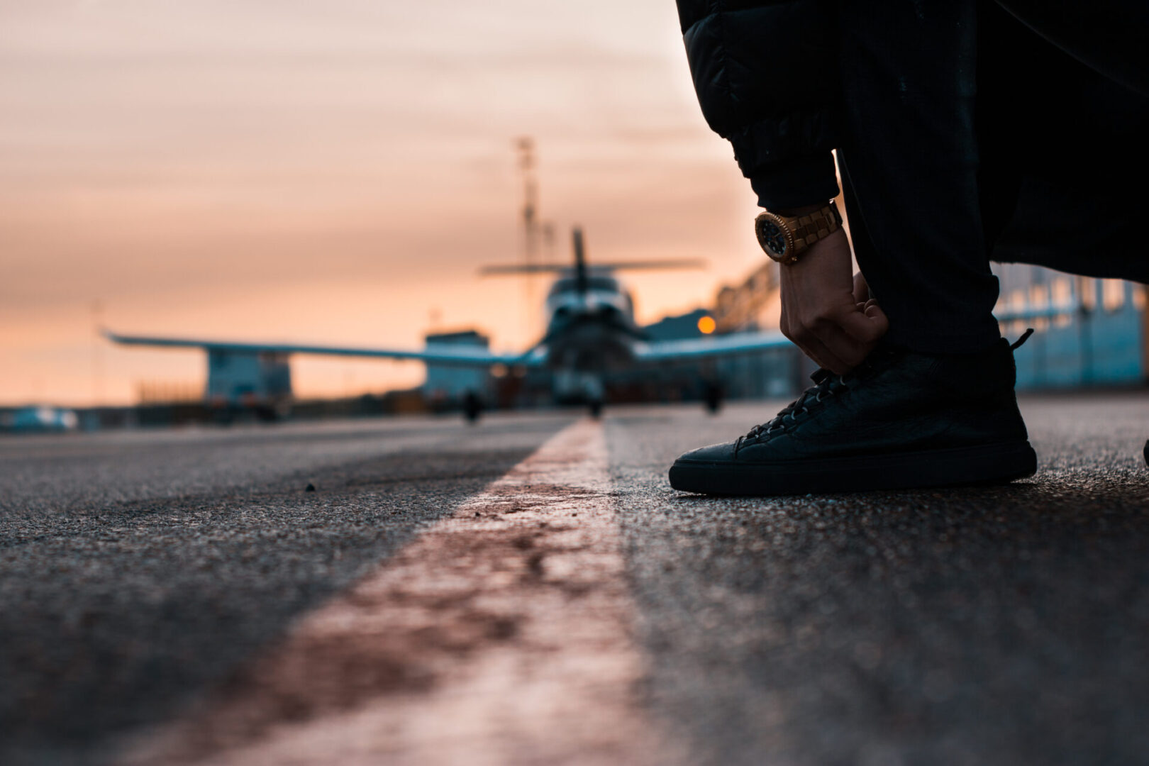 A person standing on the side of an airport runway.